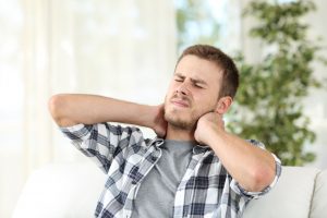 man suffering neck pain