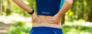 athletic woman holding her painful injured back